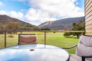a table and chairs on a balcony with a view of a field at Halls Gap Townhouse Escape in Halls Gap