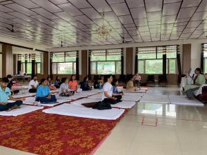 a group of people sitting on yoga mats in a room at HOTEL DEVDAR RESORT in Dharmsāla