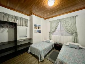 a bedroom with two beds and a window at Apartahotel Casa Soleil in Puerto Villamil