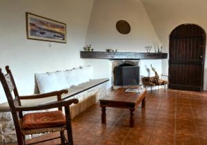 Megála KhoráfiaにあるAnemole Traditional Cretan Villaのリビングルーム(ソファ、暖炉付)