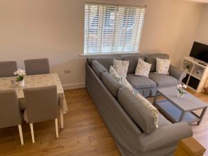 a living room with a couch and a table at Roundhill New Forest in Fordingbridge