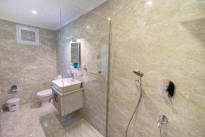 a bathroom with a shower and a sink and a toilet at Flower Hotel Patara in Patara