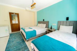 two beds in a room with blue and white at Flower Hotel Patara in Patara