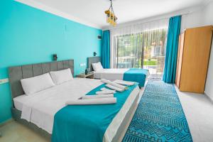 a bedroom with two beds with blue walls at Flower Hotel Patara in Patara