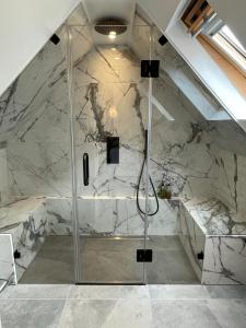 a shower in a bathroom with a marble wall at Beach Lodge in Bournemouth