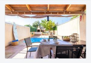 eine Terrasse mit einem Tisch, Stühlen und einem Pool in der Unterkunft Another day in Paradise in Calafell