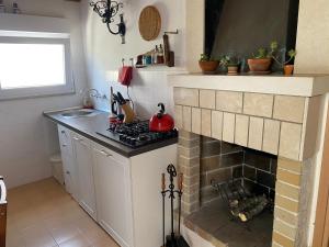 a kitchen with a brick fireplace and a stove at Island Inn in Kukljica