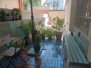 d'un balcon avec un banc vert et des plantes en pot dans l'établissement Agias Sofias Square Stunning suite, à Thessalonique