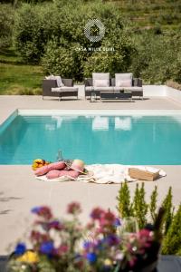 a swimming pool with a table and chairs next to a swimming poolasteryasteryastery at Casa mille olivi in Buzet +34 photos