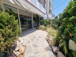 a walkway in front of a building with plants at Parthenis Riviera Hotel in Athens