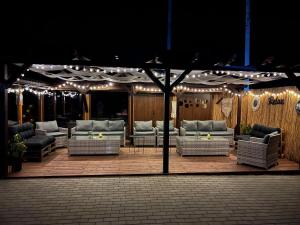 a group of couches and chairs on a patio with lights at Vama veche de la Bran in Bran