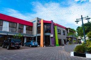 a building with cars parked in a parking lot at Nomads Court Chudleigh in Lusaka