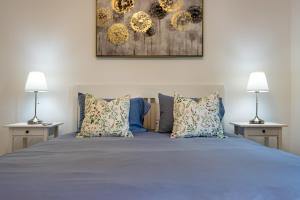 - une chambre avec un lit avec des oreillers et 2 lampes dans l'établissement Belvedere Apartment Walking Distance from Train Station, à Lugano