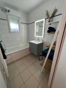 ein Badezimmer mit Waschbecken und Spiegel in der Unterkunft Appartement plage restaurant et parking privatif in Wimereux