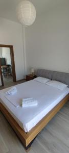 a large bed with two towels on top of it at Ninemia Apartment in Artemonas