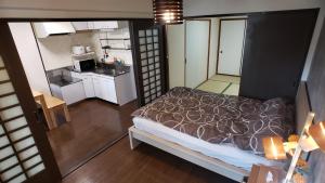 Habitación pequeña con cama y cocina en MORI Apartment 道頓堀(Dotonbori) 2DK, en Osaka