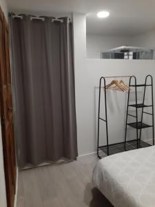 1 dormitorio con cortina de ducha gris junto a la cama en Le Logis des Templiers appartement climatisé, en Régusse