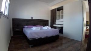 1 dormitorio con 1 cama con toallas en Abril Dptos Temporarios en San Juan