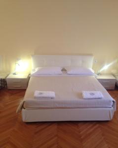 1 dormitorio con 1 cama blanca y 2 toallas en Alle Torri, en Bolonia