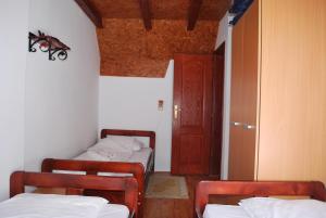 Zimmer mit 3 Betten in einem Zimmer mit einer Tür in der Unterkunft Vile M&S in Kopaonik