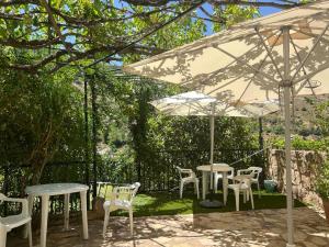 卡索拉爾的住宿－Casa Rural La Fabrica De Nacelrio，一组桌子和椅子,放在伞下