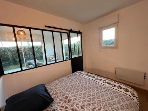 ein Schlafzimmer mit einem Bett und einigen Fenstern in der Unterkunft Appartement plage restaurant et parking privatif in Wimereux + 11 Fotos