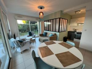 eine Küche und ein Wohnzimmer mit Tisch und Stühlen in der Unterkunft Appartement plage restaurant et parking privatif in Wimereux