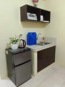 a small kitchen with a sink and a microwave at Aliyahs’s Place: Staycation in Valley Golf Cainta in Cainta