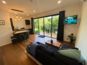 un soggiorno con un divano, un tavolo e una cucina di Kosmo’s Studio: City Style in a Retreat Setting! a Boyland