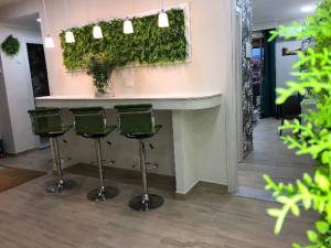 un bar con quattro sgabelli verdi in una stanza di Storico17 a Catania