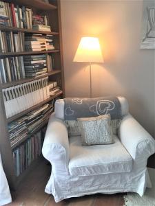 ein weißes Sofa im Wohnzimmer mit Lampe in der Unterkunft la maison des Olivettes in Uzès