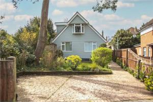a blue house with a brick driveway at Beautiful 4 Double Bedroom House in Poole with Hot tub, near Sandbanks in Poole