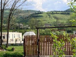 a wooden fence with a sign in a field at Kinder Valley Morlaca Cluj in Cluj-Napoca