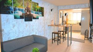 uma sala de estar com um sofá e uma mesa em ZEN Appartement 10mn CDG Airport em Villeneuve-sous-Dammartin