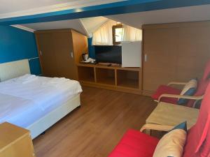 a bedroom with a bed and a tv and chairs at Sarikonaklar Garden Village in Sile