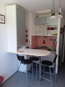 een keuken met een witte tafel en stoelen bij Studio RDC - Marina 4 - 13 allée des Pinons - 0-1 in Saint-Jean-de-Monts