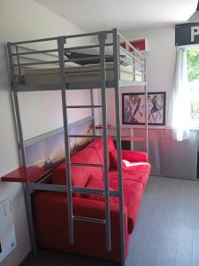 een slaapkamer met 2 stapelbedden met rode lakens bij Studio RDC - Marina 4 - 13 allée des Pinons - 0-1 in Saint-Jean-de-Monts