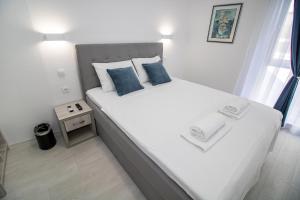 1 dormitorio con 1 cama blanca grande con almohadas azules en Villa Sonata, en Mostar