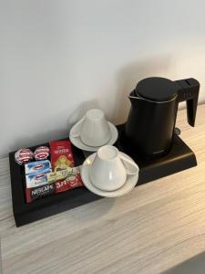 a coffee pot and plates and a book on a shelf at Villa Sonata in Mostar