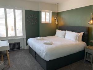 a bedroom with a large bed with a clock on the wall at Marina Court in Weymouth