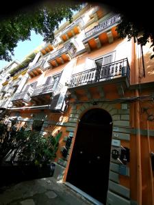 - un bâtiment avec une porte noire et un balcon dans l'établissement Palermo centro Zoe, à Palerme