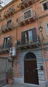 - un bâtiment avec une porte en bois et un balcon dans l'établissement Palermo centro Zoe, à Palerme