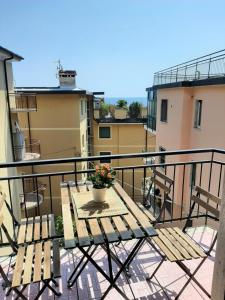 un tavolo e sedie su un balcone con un vaso di fiori di WONDERFUL NOLI - appartamento Noli Liguria Italia a Noli