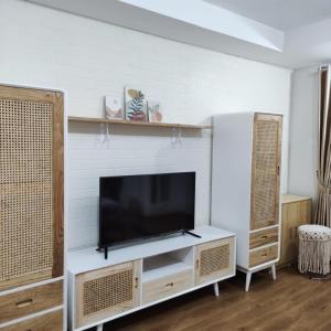a living room with a flat screen tv on a tv stand at Apartemen Strategis Yogyakarta in Seturan