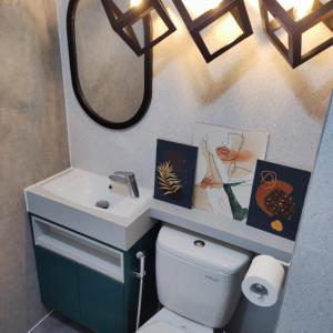 a bathroom with a sink and a toilet and a mirror at Apartemen Strategis Yogyakarta in Seturan