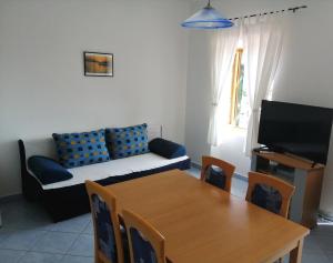 sala de estar con mesa y sofá en Apartments Dalmatian Stone House, en Turanj