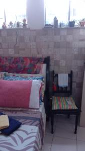 um quarto com 2 camas, uma cadeira e janelas em Se hospede num Cantinho Gourmet em Salvador