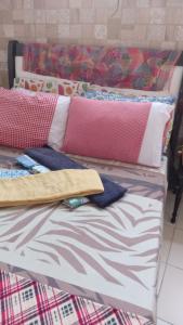 uma cama com almofadas em cima em Se hospede num Cantinho Gourmet em Salvador