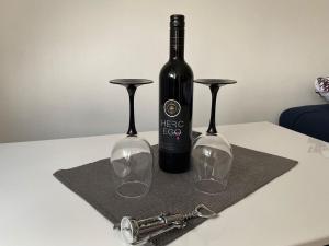 a bottle of wine and two wine glasses on a table at Studio apartman BF in Slavonski Brod +6 photos