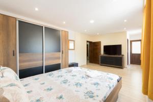 een slaapkamer met een bed en een flatscreen-tv bij Къща за гости Мечта in Yagodina